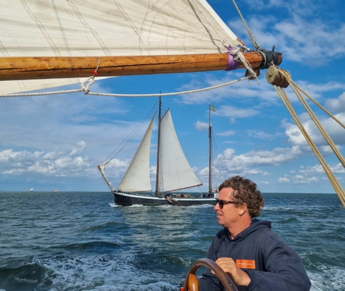 Skipper Laurens am Ruder von sein Schiff Johanna Engelina am Wattenmeer